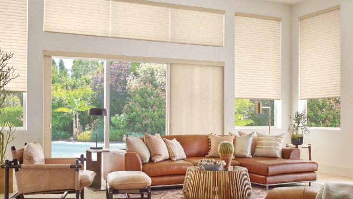Beautifully decorated living room with large windows and sliding glass doors adorned with Hunter Douglas Sonnette® Roller Shades at White House Designs For Life near Fairfield, New Jersey