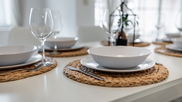 Image of a small dining room with a set table with white dinnerware and wine glasses