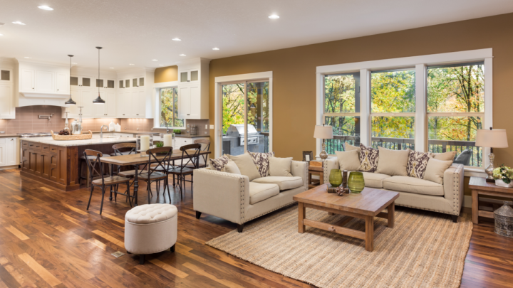A trendy living room and kitchen with tobacco brown walls and a dark wood island