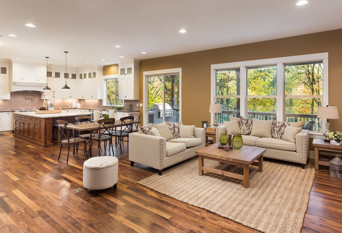 A trendy living room and kitchen with tobacco brown walls and a dark wood island